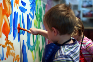 Enfant réalisant une fresque dans le cadre d'une activité à la crèche